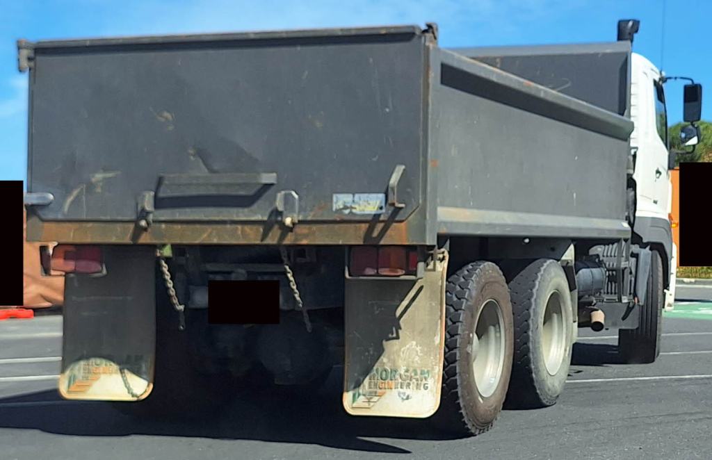 Unmarked dump truck that is engaging in illegal dumping enters a development site.